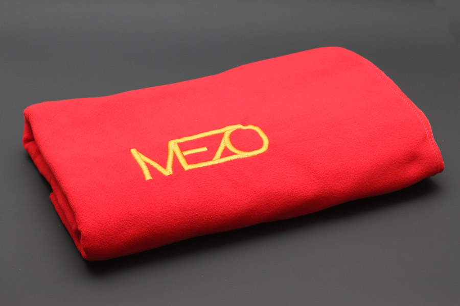 фото красного сложенного пледа из флиса с золотой вышивкой